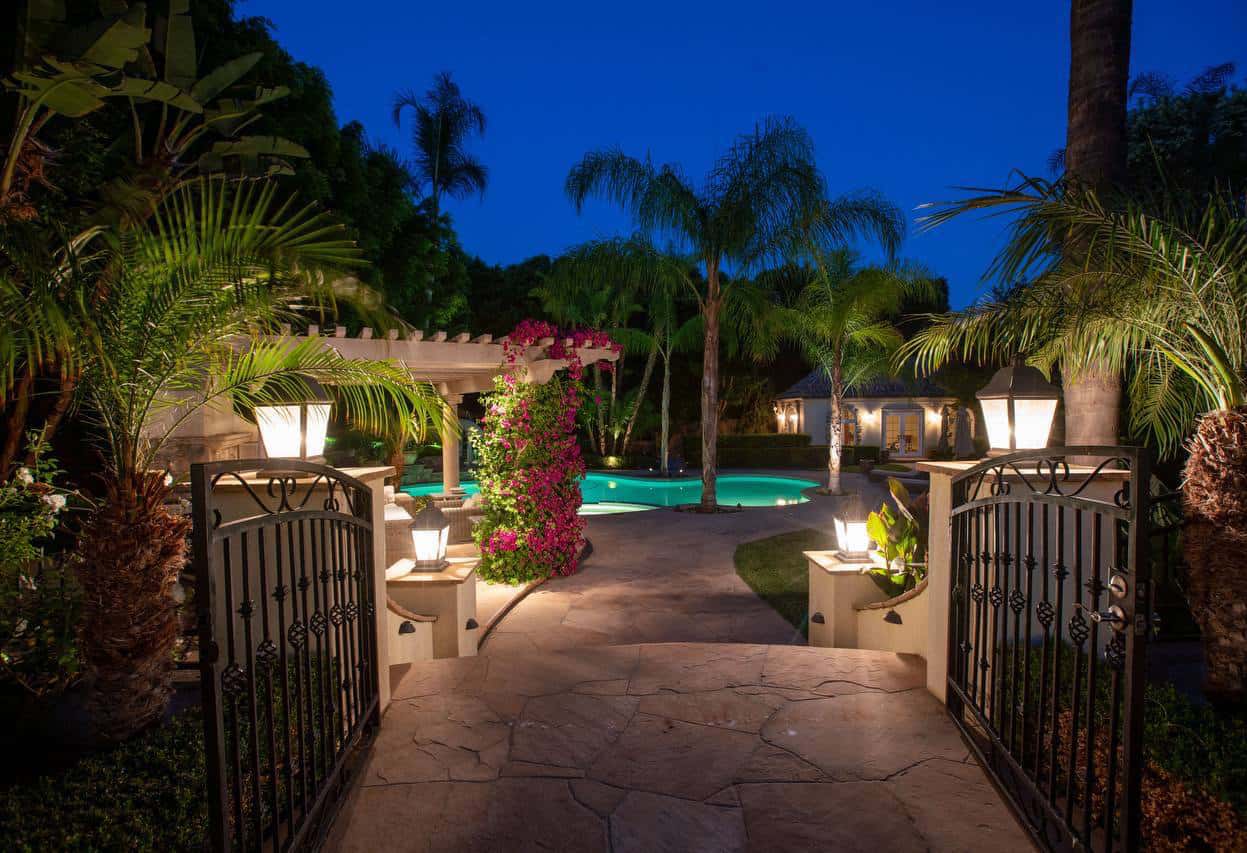 a photo of 4 seasons detox recovery center backyard, the path leading away from the home toward a pool with surrounding palm trees